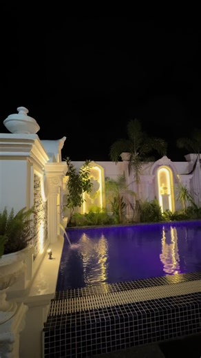 Luxurious Nighttime Pool Area with Tropical Ambiance
