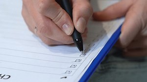 clip-1103371291-woman-marks-completed-tasks-to-do-list