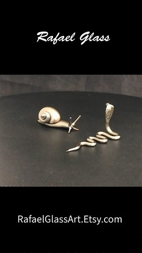 🐌 🐍 Standoff Cobra Snake vs Snail… Who will prevail?? RafaelGlassArt.Etsy.com . . #glass #boro #artlover #artcollector #glassart #artist #art #borosilicate #borosilicateglass #flameworking #lampwork #lampworking #glassblowing #glasssculpture #sculpture #figurines #glassfigurines #animallovers #collectables #gift #handmade #electrum #metallic #cobra #snail #electrumglass | Rafael Glass