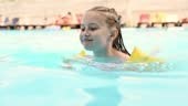 Preteen girl swimming in pool in sunny summer day outside. Female kid...