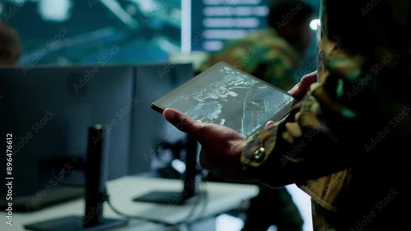 Military officer leads cybersecurity operations in a high tech operation room command post, ensuring data protection. Soldiers working with cctv surveillance systems, satellite imagery. Camera A.