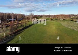 Valmiera, Latvia - November 18, 2025: Wide aerial view of a green golf course with scattered trees and two distant golfers walking across the fairway; large open field provides ample copy space Stock Video Footage - Alamy