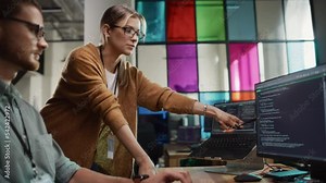 Male Programmer Showing Code on Desktop Computer to Female Lead Developer in Stylish Office Space. Caucasian Woman Helps Her Colleague With Useful Coding Hacks, Points at Erros on Display.