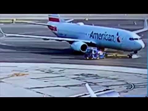 American Airlines plane runs over and crushes towing vehicle.