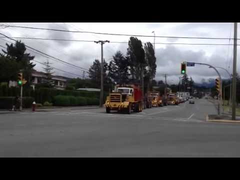 Off highway logging trucks trough town