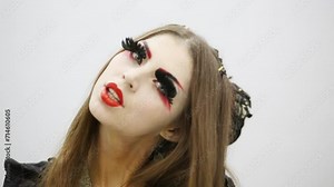 Woman with make up of geisha with false eyelashes blinks