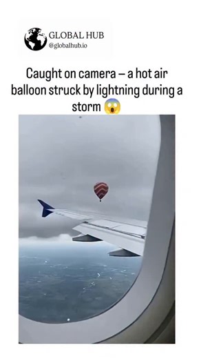 GLOBAL REEL HUB on Instagram: "The video depicts a hot air balloon struck by lightning from an airplane window view, but frame analysis shows static clouds, inconsistent motion, and artificial fire effects, confirming it's AI-generated rather than real footage. No credible news sources report a 2025 lightning strike on a hot air balloon; the clip misrepresents Brazil's June 2025 Praia Grande crash, where a fire—not lightning—killed 8 of 21 passengers mid-flight. Posted by @Crazymoments01 , an ac