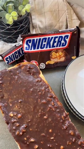 עוגת גבינה סניקרס 🥜 והיא לא כזו מסובכת להכנה מתכון של לימור כץ מנבחרת @israeli_kitchen תכינו את הבסיס, אחריו את רוטב הקרמל ובזמן שהוא מצטנן תכינו את בלילת הגבינה. *אם תרצו גרסה ארוכה יותר של הסרטון כולל הכנת הקרמל כתבו ללימור שמתויגת בסרטון והיא תשלח בשמחה. מצרכים: לבסיס: 170גר פתיבר 50גר שוקולד חלב 80גר חמאה לערבב פתיבר טחון עם חמאה מומסת , להוסיף שוקולד מומס ולערבב. רוטב קרמל- 50 מ״ מים 110גר סוכר 50גר חמאה 125גר שמנת מתוקה מחוממת 80גר בוטנים קצוצים הכנה: להכניס לתוך קלחת מים וסוכר ולחמם על ה