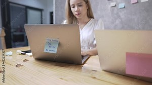Asian blonde female office worker using laptop computer to gather business information, concentrated staring on screen, typing on keyboard, late working at office, successful dedicated employees Stock Video