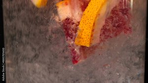 Pouring fizzy soda into glass swirling around blood orange grapefruit slices. Creating citrus symphony of bubbles and aromas in refreshing lemonade. making cocktail in close-up