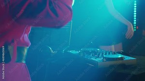 DJ Santa Claus mixing tracks in a nightclub at a Christmas and New Year party or Corporate events. Senior disc jockey as Santa listening music, headphones, laptop, mixer controller player, turntable.