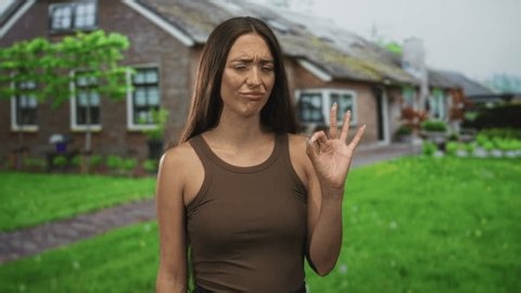 clip-3983892099-young-hispanic-woman-making-ok-sign-building