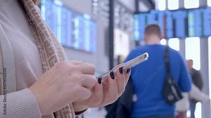 Seamless Traveler Experience: A Woman Utilizing Smartphone Connectivity in an International Airport Amidst a Bustling Scene of Passengers, Luggage, and Informational Displays