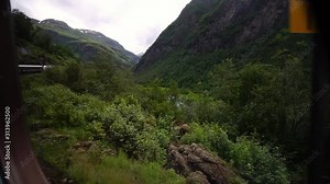 Flamsbana train in Flam. Famous scenic Norwegian train adventure for fjord cruise ship tourists. Mountains and waterfalls nature of Norway.