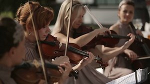 Group of violinists are playing music outdoor