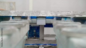 Close Up. Granite Rock Slab Moving On Automated Conveyor Belt At Manufacturing Plant. Conveyor Transports Granite Rock Slab To Next Processing Stage. Granite Rock On Automated Conveyor Production Line