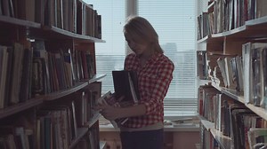 Young woman arranging the books at the library - Free Stock Video