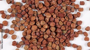 Golden brown marrowfat dehydrated peas spinning clockwise - shallow depth of field