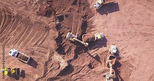 Top down view of several excavators working on a construction site. Heavy industrial machinery. Excavators loading Articulated hauler Trucks.