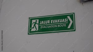 Evacuation route signs guide people to safety during emergencies, marking the fastest exit paths. Essential for disaster preparedness, they help prevent confusion in critical situations. Stock Video