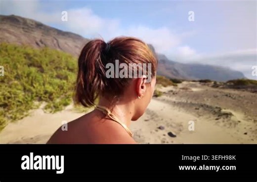 Young woman hiking in a desert landscape with mountains on a sunny summer day in Lanzarote, Spain Stock Video Footage - Alamy