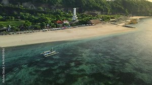Pandawa beach with scenic landscape, lighthouse and fishing boat in ocean at Bali island.