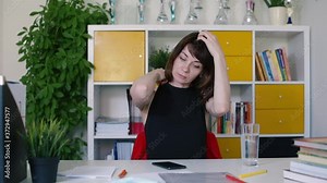 Office worker woman sitting at the table preparing for the work process. Checks messages in the messenger. Focuses on getting information.