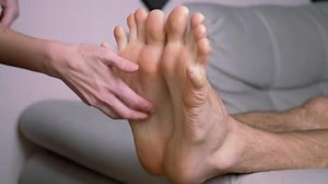 Female Hands Tickle Bare Male Feet, Toes, Outstretched on the Sofa. Time Lapse