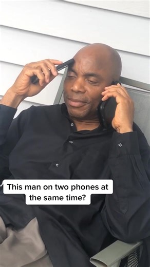 Multitasking Mastery: Man uses two phones simultaneously