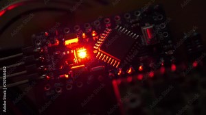 Microcircuit with electronic components connected to power supply. Small electronic circuit with burning red LED light bulb. Microcircuit, resistors and chips