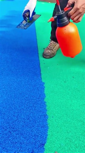 Installing rubber flooring smoothing blue and green granules