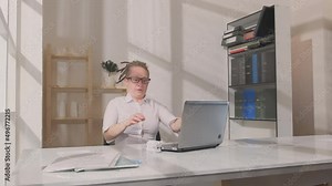 Sleeping woman in workplace in office wakes up when she is unexpectedly disturbed and starts working on laptop.
