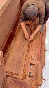 a worker using a hand tool to meticulously smooth a decorative timber surface