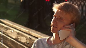 Talking over phone outdoors young male makes a call happy