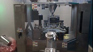 Inside a modern medical factory. Medical supplies production of antibiotic tablets. A piece of machine equipment is working automatically. Medical encapsulation machine. Clear glass tank. Making Pills Stock Video
