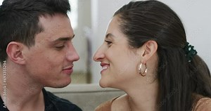 Smile, love and couple kiss in home, care and bonding together on living room sofa. Happy man, woman and touch lips in romantic connection, healthy relationship and trust on valentines day in house