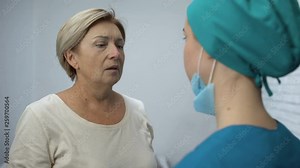 Nurse telling mature patient shocking news, terrified woman crying hysterically