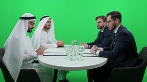 clip-1086950681-international-business-meeting-process-signing-financial-documents