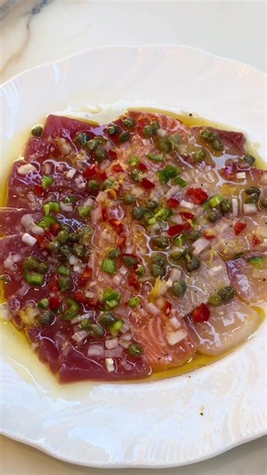 Crudo 🐟 🌶️ 🫒 The most tasty dish EVER. It is so simple, fresh and bursts with flavour, with acidity from the citrus, spice from the chilli, made complete with a drizzle of olive oil to bring balance! @Get Drizzling Ingredients (Serves 4) 6 slices of salmon sashimi, tuna sashimi and kingfish sashimi 2 tablespoons olive oil 1 tablespoon lemon zest 1-2 tablespoons lemon juice 1-2 tablespoons orange juice ½ teaspoon sea salt flakes ¼ teaspoon pepper 1.5 tablespoons capers 1 tablespoon fresh red a