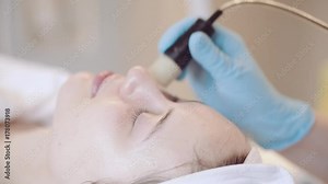 Young Woman getting a cosmetic medicine spa treatment, close up. 4K UHD, Slow Motion. Beautician hands at work, providing led light skin treatment therapy to a girl face. Special beauty equipment.