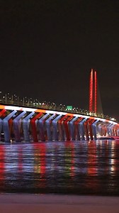 🍁🥇 Le pont illuminé aux couleurs du Canada pour célébrer la médaille d’or de Megan Oldham aux Jeux olympiques d’hiver de Milan-Cortina 2026. Il sera également illuminé ce soir pour célébrer les médailles d’or de Valerie Maltais, Ivanie Blondin et Isabelle Weidemann. – The bridge lit up in Canada’s colours to celebrate Megan Oldham’s gold medal at the Milano-Cortina 2026 Winter Olympic Games. It will also be illuminated tonight to celebrate the gold medals won by Valérie Maltais, Ivanie Blondin