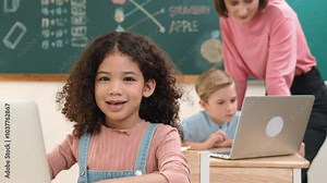 Attractive girl coding prompt while looking at camera at STEM class while happy teacher checking smart boy software program. Diverse student study about programing code and computing system. Pedagogy.