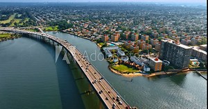 The Throgs Neck Bridge leading to the Bay Terrace in Queens, New York. Lively traffic on the bridge and beautiful cityscape from top view.