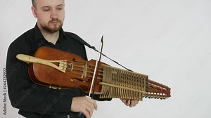young musician demonstrates the technique of playing nickelharpa, a medieval authentic Swedish Scandinavian musical instrument