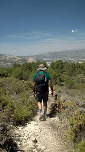 ralenti, vue arrière d'un randonneur marchant sur un sentier lors d'une journée d'été ensoleillée