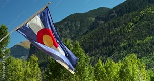Colorado state flag waves in the Rocky Mountains wilderness Stock Video