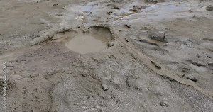 Muddy Vulcanos located in Buzau County, Romania, a National Landmark, Gas bubbles coming out a mud volcano. Paclele mici and Paclele Mari
