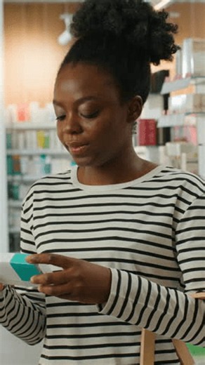 clip-4185209503-african-american-woman-holding-pills-reading-instruction