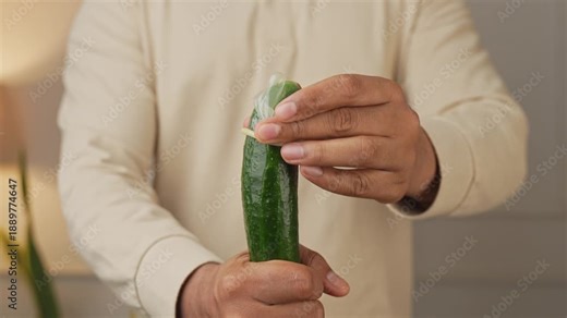 Showing how to use a condom by putting it on a cucumber.