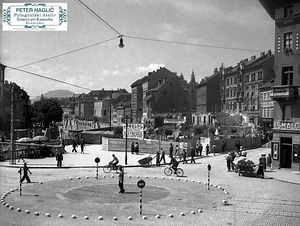Na katerem delu brega Ljubljane se nahajamo? https://ozivi-stare-slike.replit.app Kolesarji, pešci, vozovi, gradbišče sredi mesta in ulice, kjer je promet urejal človek – ne semafor. Mesto v nastajanju, polno gibanja, dela in vsakdanjega življenja. To je bila Ljubljana, ko se je vse dogajalo počasneje, a bolj človeško. Ko si se ustavil sredi krožišča, pogledal okoli sebe in videl ljudi, ki so mesto gradili – korak za korakom. Poglejte detajle: 🔹 tlakovane ulice 🔹 ročne vozičke 🔹 kolesarje bre